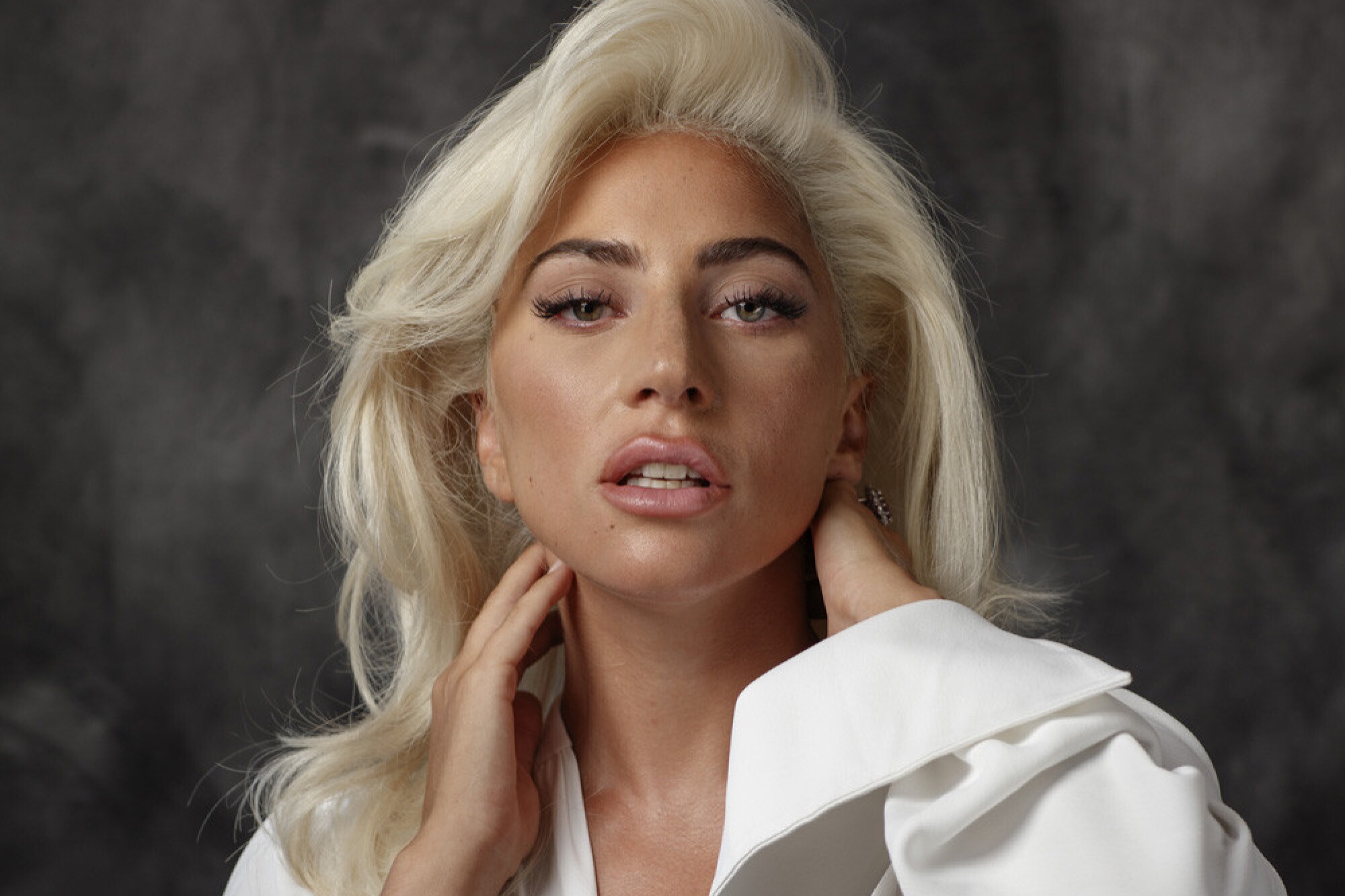 Lady Gaga se colle du ruban adhésif sur le visage.